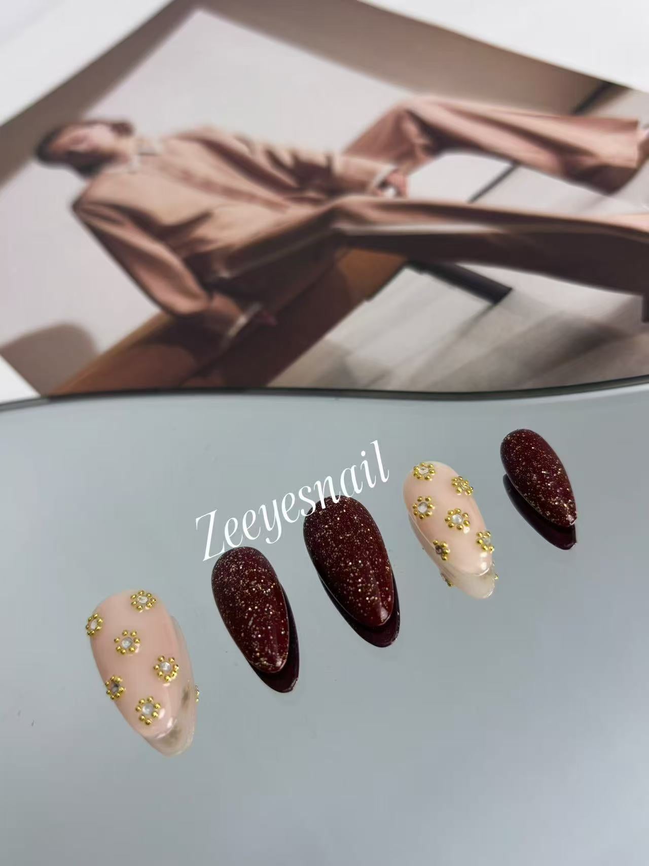 Burgundy Glitter Almond Nails with Gold Floral Accents