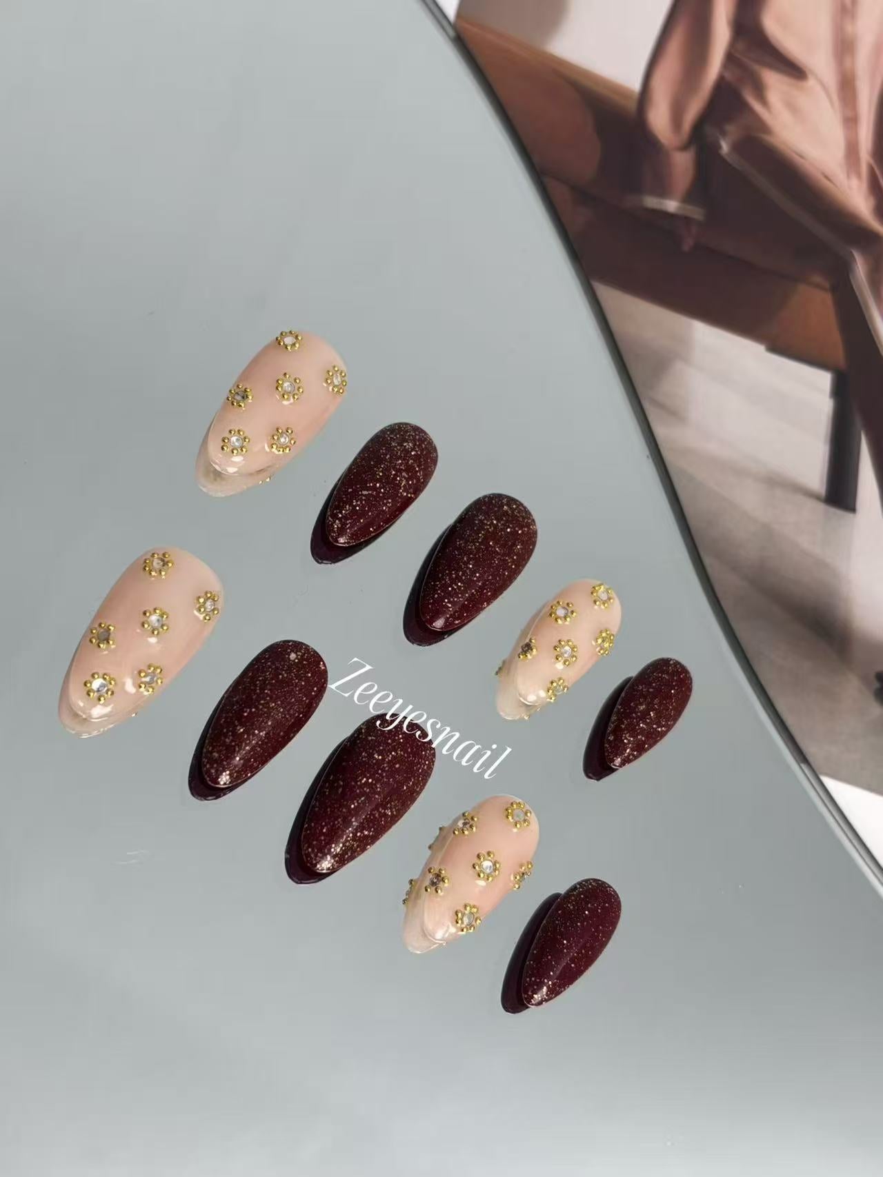 Burgundy Glitter Almond Nails with Gold Floral Accents