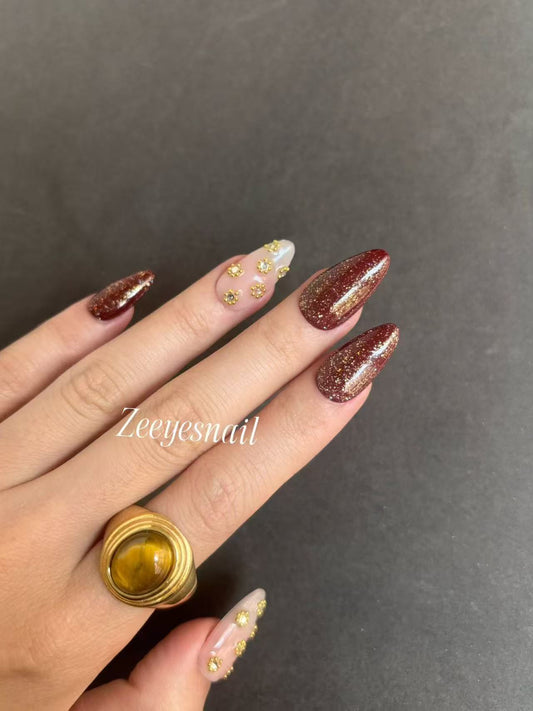 Burgundy Glitter Almond Nails with Gold Floral Accents