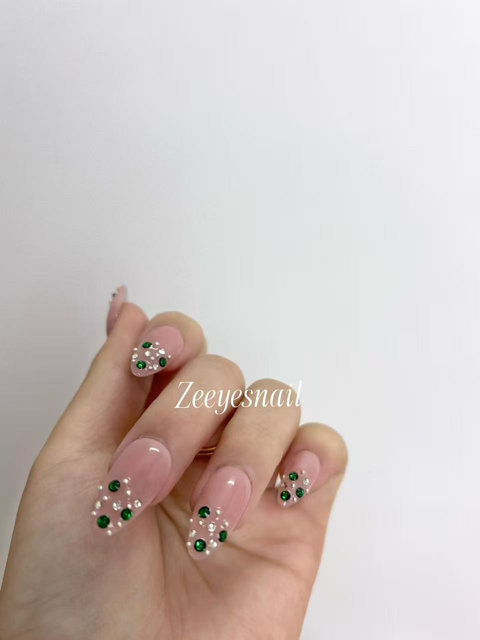 Blush Pink Almond Nails with Emerald Crystal Accents