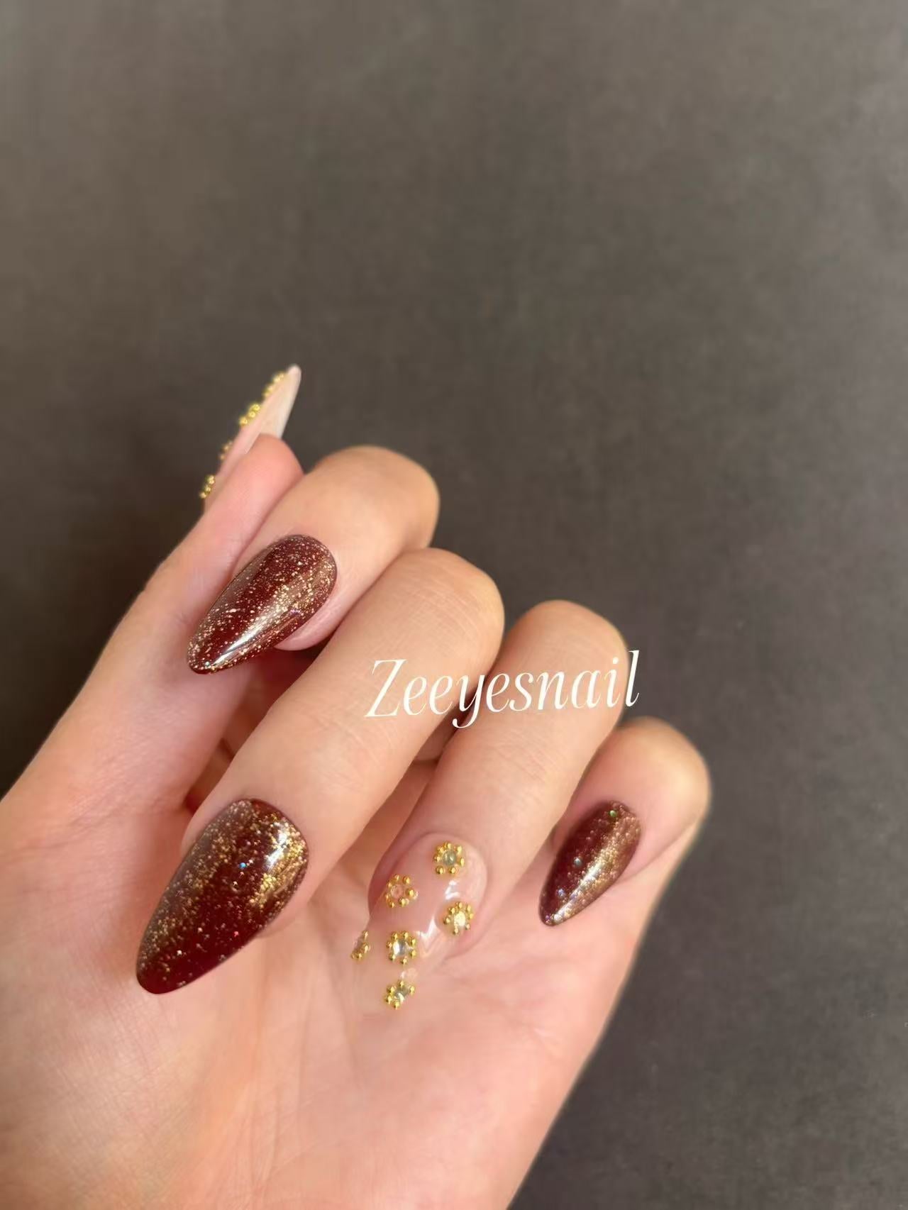 Burgundy Glitter Almond Nails with Gold Floral Accents